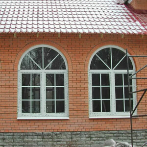 Кирпичный дом с арочными окнами из пластика